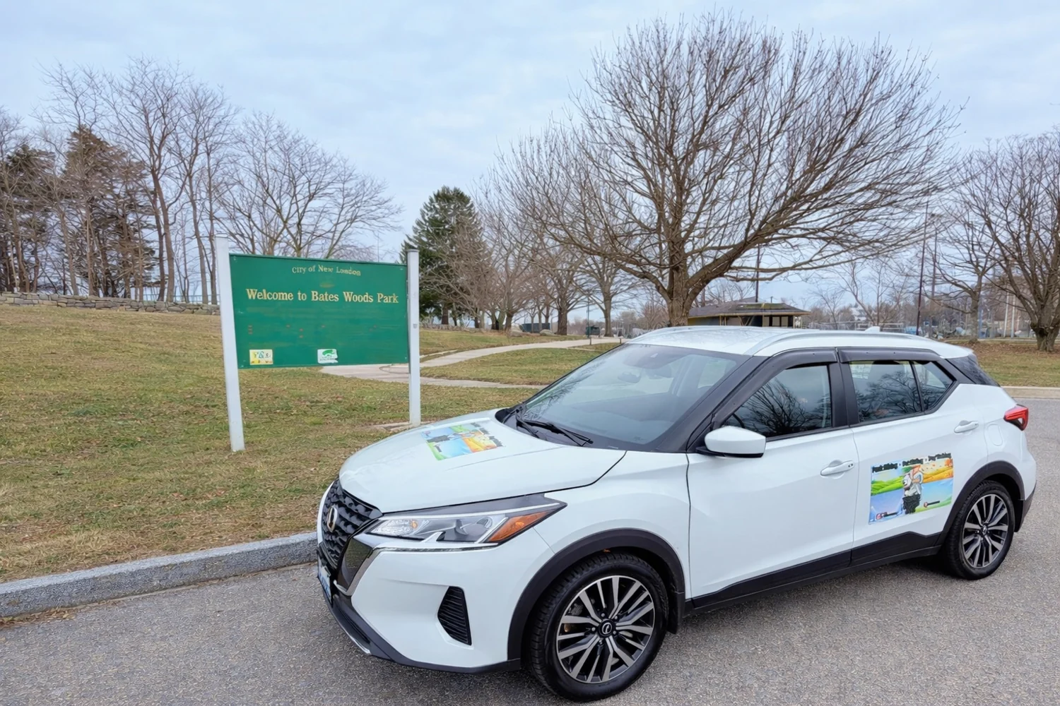 Tom’s Dogs vehicle parked beside the Bates Woods Park sign in New London